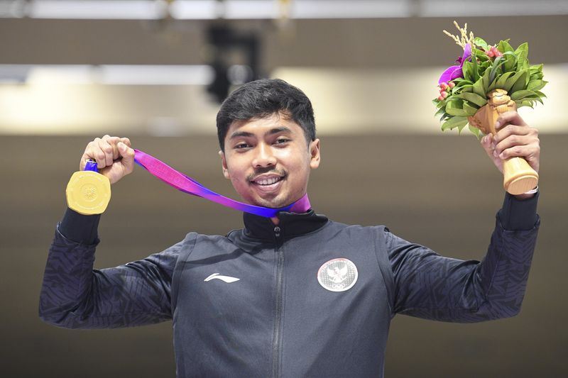 Petembak tunggal putra Indonesia Muhammad Sejahtera Dwi Putra berpose dengan medali emasnya usai upacara penghargaan pemenang final 10 meter running target  Asian Games 2022 di Fuyang Yinhu Sports Centre, Hangzhou, China, Senin (25/9/2023). Muhammad Sejahtera Dwi Putra berhasil mempersembahkan medali emas pertama untuk Indonesia usai mencatatkan poin total poin 578. ANTARA FOTO/M Risyal Hidayat/aww.