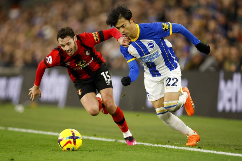 Bournemouth's Adam Smith, left, chases for the ball alongside Brighton's Kaoru Mitoma during the English Premier League soccer match between Brighton and Hove Albion and Bournemouth at the Amex Stadium in Brighton, England, Saturday, Feb. 4, 2023. (AP Photo/David Cliff)