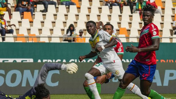 Senegal's Lamine Camara, center, gestures as he scores his side's second goal past Gambia's goalkeeper Baboucarr Gaye, bottom left, during the African Cup of Nations Group C soccer match between Senegal and Gambia at the Charles Konan Banny stadium in Yamoussoukro, Ivory Coast, Monday, Jan. 15, 2024. (AP Photo/Sunday Alamba)