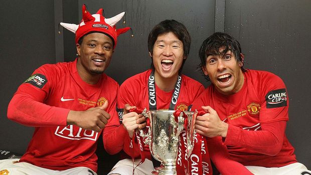 LONDON, ENGLAND - MARCH 1:  (MINIMUM USAGE FEE APPLIES - 250 GBP OR LOCAL EQUIVALENT) Patrice Evra, Ji-Sung Park and Carlos Tevez of Manchester United pose in the dressing room with the Carling Cup trophy after the Carling Cup Final match between Manchester United and Tottenham Hotspur at Wembley Stadium on March 1 2009 in London, England. (Photo by John Peters/Manchester United via Getty Images)